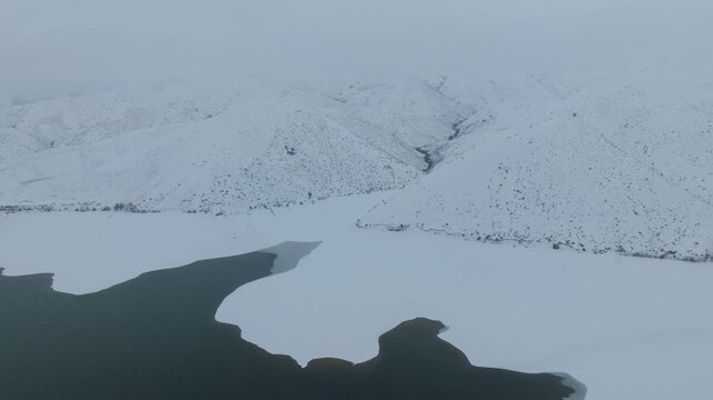 Aerial view of the snow-covered landscape surrounding Lucky Peak Lake in Ada County, Idaho, United States.