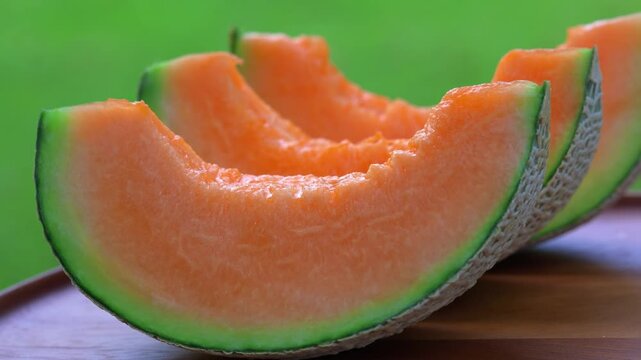 fresh cantaloupe melon slices with vibrant orange flesh and green rind