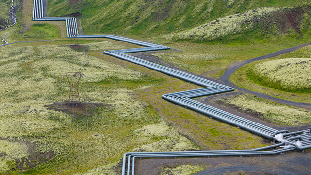 Aerial view of Hellisheidi Geothermal Power Plant with zigzagging steam pipelines traversing the mossy volcanic landscape of Olfus, Sveitarfelagid Olfus, Iceland.
