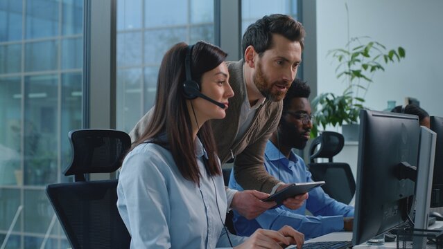 Three multiethnic operators working in call center ceo checking satisfied support woman talking with clients celebrating business success group diversity team work in callcenter boss check good job