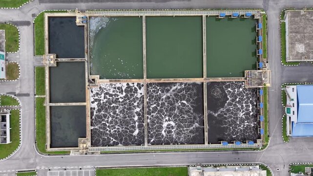 Top down drone shot of wastewater treatment basins showing aeration sludge infrastructure geometric layout