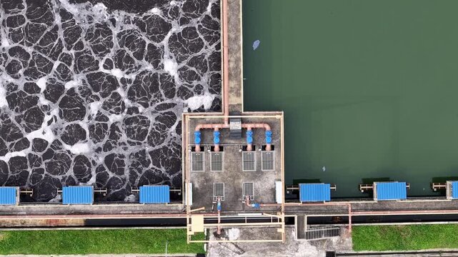 Top down aeration basins, piping and effluent water at industrial wastewater treatment plant.