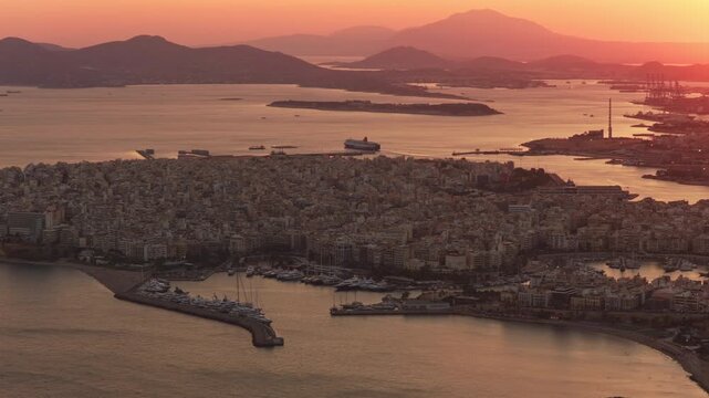 Stunning aerial perspective of the city of piraeus and its bustling port near athens, greece, with boats and ferries moving across the saronic gulf during a vibrant, warm sunset