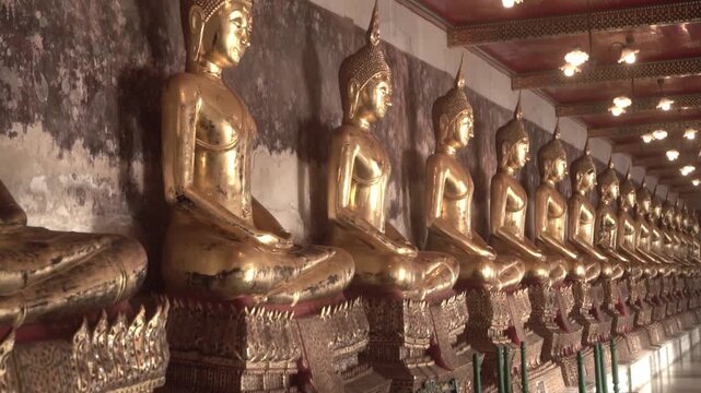 Row of ancient buddha statues in buddhist temple