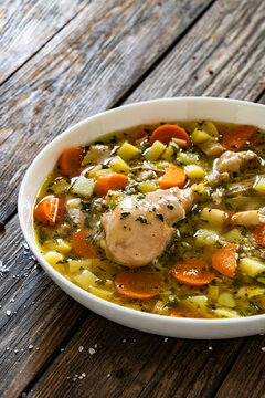 Krupnik - polish barley soup with chicken meat on wooden table
