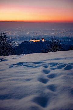 View of the illuminated Medvedgrad castle on a snow-covered mountain slope overlooking the city lights of Zagreb at dusk, Zagreb, Grad Zagreb, Croatia.