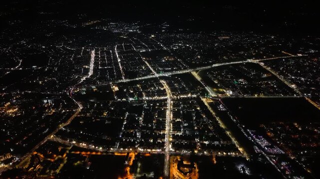 Aerial night view of an urban landscape in Syria featuring glowing city lights and illuminated streets.  Post-war Syrian cityscape and daily life at night.