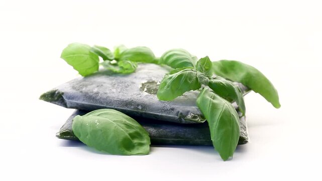 Vacuum packed basil with fresh green leaves on bright white background