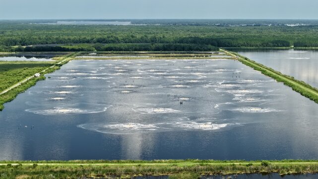 Aerial view of the Georgia-Pacific Palatka Operations industrial water treatment pond with aerators creating circular patterns on the water surface in Palatka, Florida, United States.