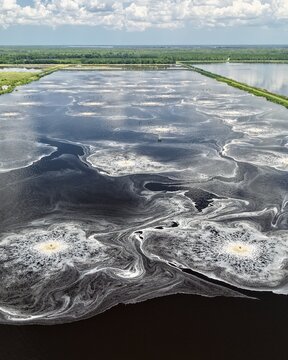 Aerial view of Georgia-Pacific Palatka Operations industrial water treatment pond with aerators creating circular patterns in the dark water in Palatka, Florida, United States.