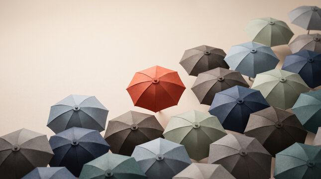 Strategic market positioning concept featuring unique orange umbrella leading grey crowd representing business innovation and corporate individuality