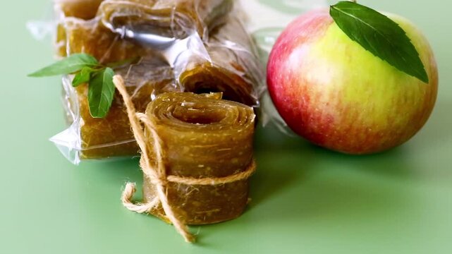 Sweet dried apple pastila packed with apple on green background