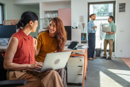 Diverse colleagues collaborating and discussing in modern office