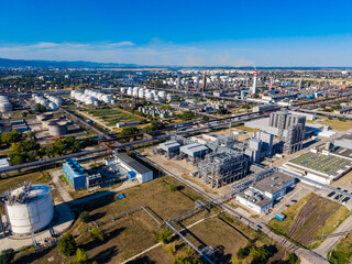 Fototapeta premium View of a large industrial complex in a city with pipelines and storage tanks during daytime