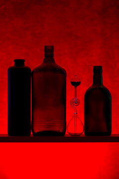 Still life with silhouettes of bottles on a red background