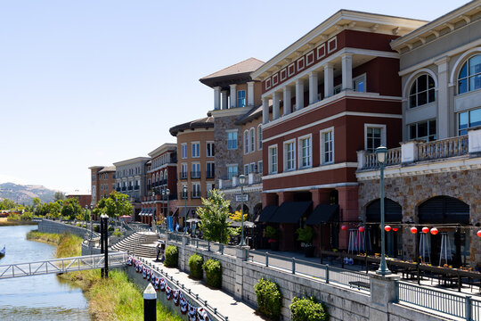 The scenic Napa Riverfront Promenade featuring multi story modern buildings with stone accents.