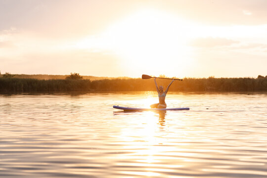 Girl Enjoys Summer Evening on River While Paddling