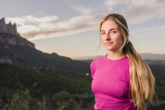Confident young hispanic woman enjoying outdoor climbing adventure in montserrat mountains