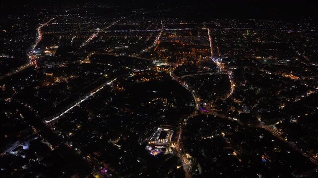 Aerial night view of an urban landscape in Syria featuring glowing city lights and illuminated streets.  Post-war Syrian cityscape and daily life at night.