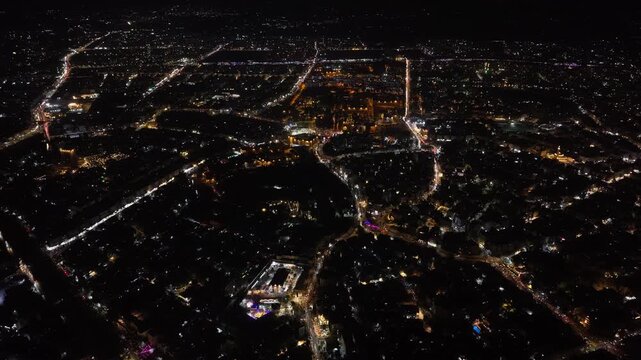 Aerial night view of an urban landscape in Syria featuring glowing city lights and illuminated streets.  Post-war Syrian cityscape and daily life at night.