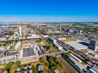 Fototapeta premium Industrial area with factories and equipment near a clear sky and green fields during the day