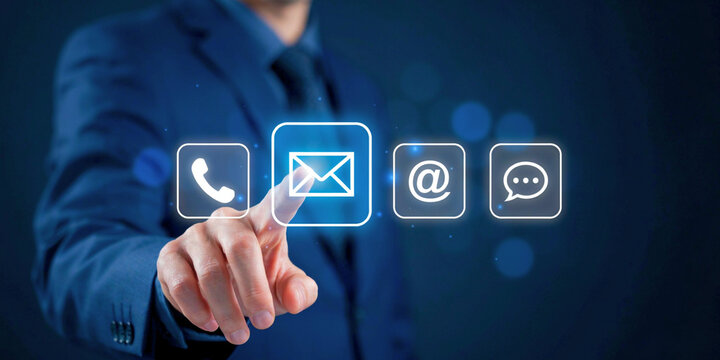 Business professional touching illuminated email icon on virtual screen, symbolizing digital communication, customer contact, and online support services
