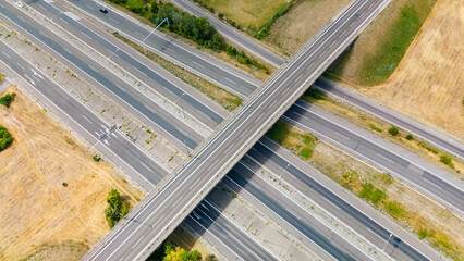 Fototapeta premium A view of a highway interchange with multiple roads crossing at a rural location during daylight