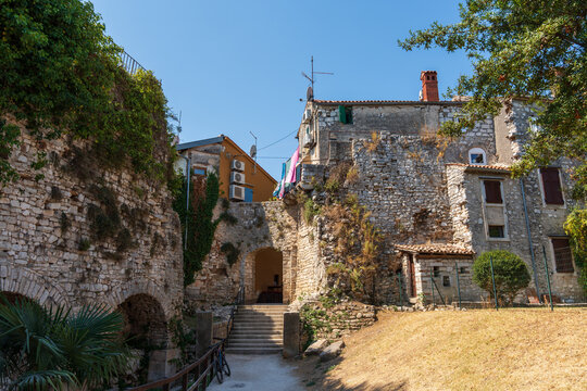 ancient walls of the city of Porec, Croatia, with a characteristic entrance gate and a staircase leading to the old town.
