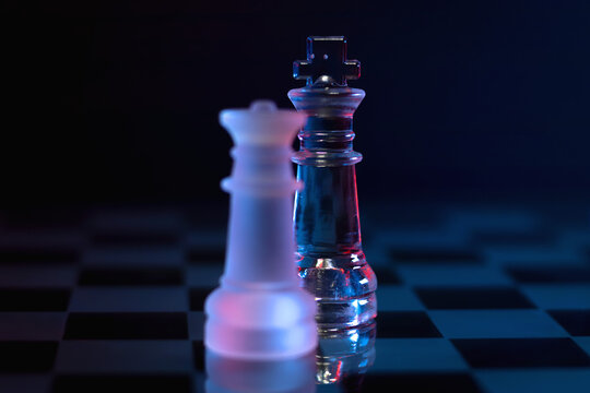 Dramatic glass chess set with red and blue lighting symbolizing  control, domination or decision-making.