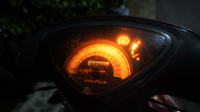 Purwokerto, Indonesia - 28 June 2026: Illuminated Yamaha Mio speedometer glowing orange at night.