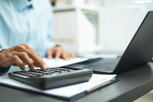 using calculator budget with calculating tax; a calculation desk scene. using guides buyer choices, calculator frames the scene, and budget adds useful meaning. In a clear visual scene.