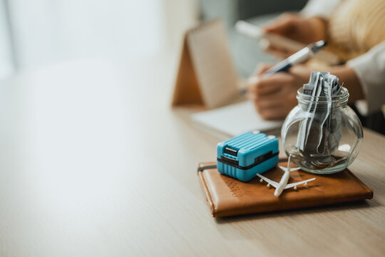 travel savings vacation with suitcase airplane; a travel savings desk scene. travel guides choices, savings frames meaning, and vacation supports buyers. Clear visual context supports stock buyers.