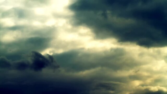 Time-lapse of dramatic storm clouds with golden sunlight breaking through, moody and atmospheric sky