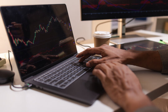 Professional trader analyzing stock market charts on laptop, tablet, and monitor while reviewing candlestick patterns, technical indicators, and market trends to support informed investment decisions.