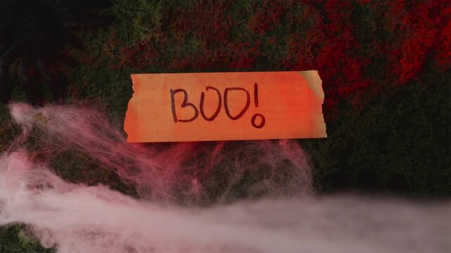 BOO sign on foggy red moss with strobe lightning flashes