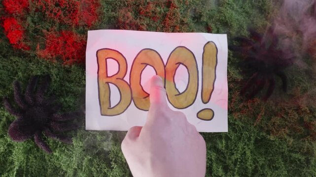 Finger pointing at BOO text with smoke explosion in lightning