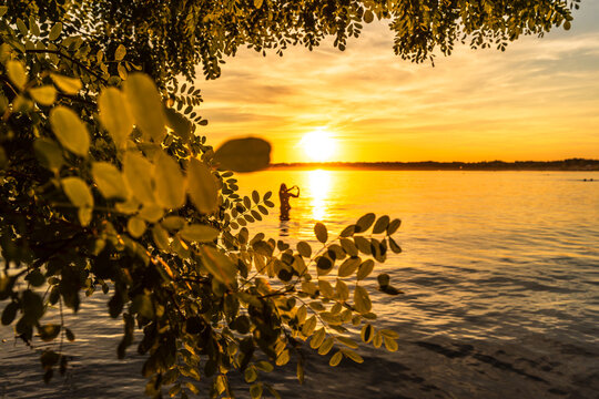 Silhouette eine jungen Frau im Cospudener See bei Leipzig an einem wundersch&ouml;nen Sonnenuntergang