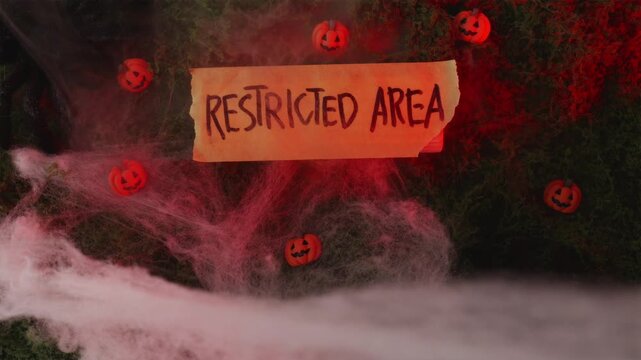 Restricted Area sign with mini pumpkins in red light fog