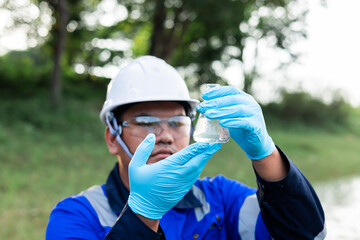 Naklejka premium Environmental scientist analyzing water sample for contamination and chemical residues in freshwater ecosystem.