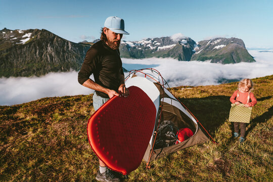 Family father and child packing camping gear in mountains active travel vacations outdoor parent and kid hiking in Norway together adventure trip eco tourism weekend getaway