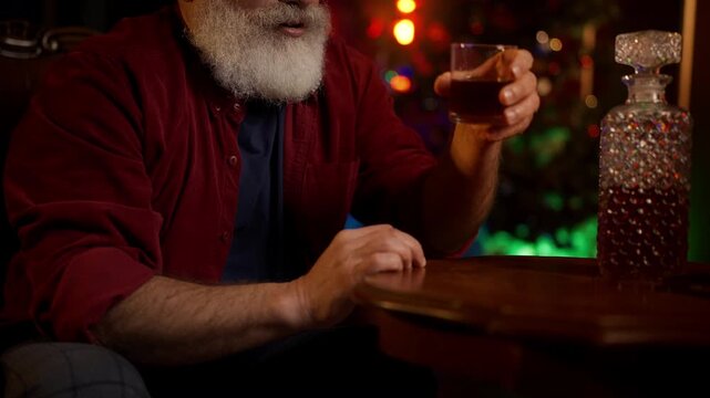 Lonely bearded man in his 50s drinks liquor, coping with Christmas depression