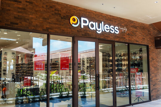 Sira village mall, Bali, Indonesia, August 16,2026: Illuminated Payless storefront with brick facade, glass entrance doors, and footwear displays at a modern shopping mall.