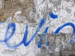 Blue spray paint graffiti on weathered concrete wall urban street art © Pietes Lit