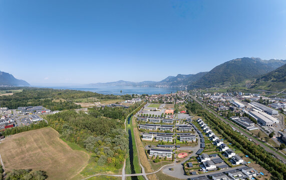 Aerial view of the industrial zone and residential area near the A9 highway with Lake Geneva in the background in Villeneuve, Vaud, Switzerland.