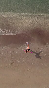 Aerial drone view of woman shadow boxing and kickboxing on the beach during summer training