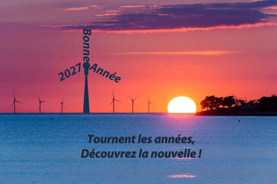 Bonne ann&eacute;e 2027, ailes d'une &eacute;olienne formant le slogan sur l'horizon. &Eacute;l&eacute;gante carte de v&oelig;u sur fond de mer et de soleil couchant.
