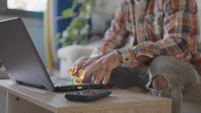 Man in checkered shirt ignoring Emojis alerts from phone. Overwhelmed by digital notifications while working at home
