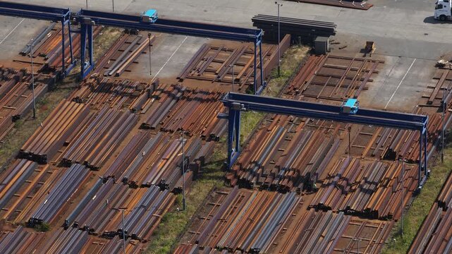 Aerial view of an industrial warehouse storing steel plates with cranes beside a large steel manufacturing facility in the United Kingdom.