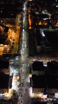 Aerial night view of an urban landscape in Syria featuring glowing city lights and illuminated streets.  Post-war Syrian cityscape and daily life at night.