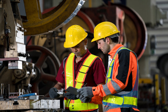 two professional engineer, worker, technician use clipboard discuss work, walk in steel metal manufacture factory plant industry. man and woman wear hard hat check quality machine. work, engineer,